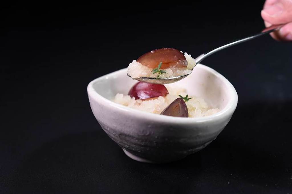 〈Orchid蘭〉餐廳本季新套餐的前甜點，主體是用洋梨和梨子利口酒製成的義式冰沙，碗內底層是用洋梨和百里香作的泡沫，葡萄則糖煮後加入柚子增添些許酸度。（圖／姚舜）