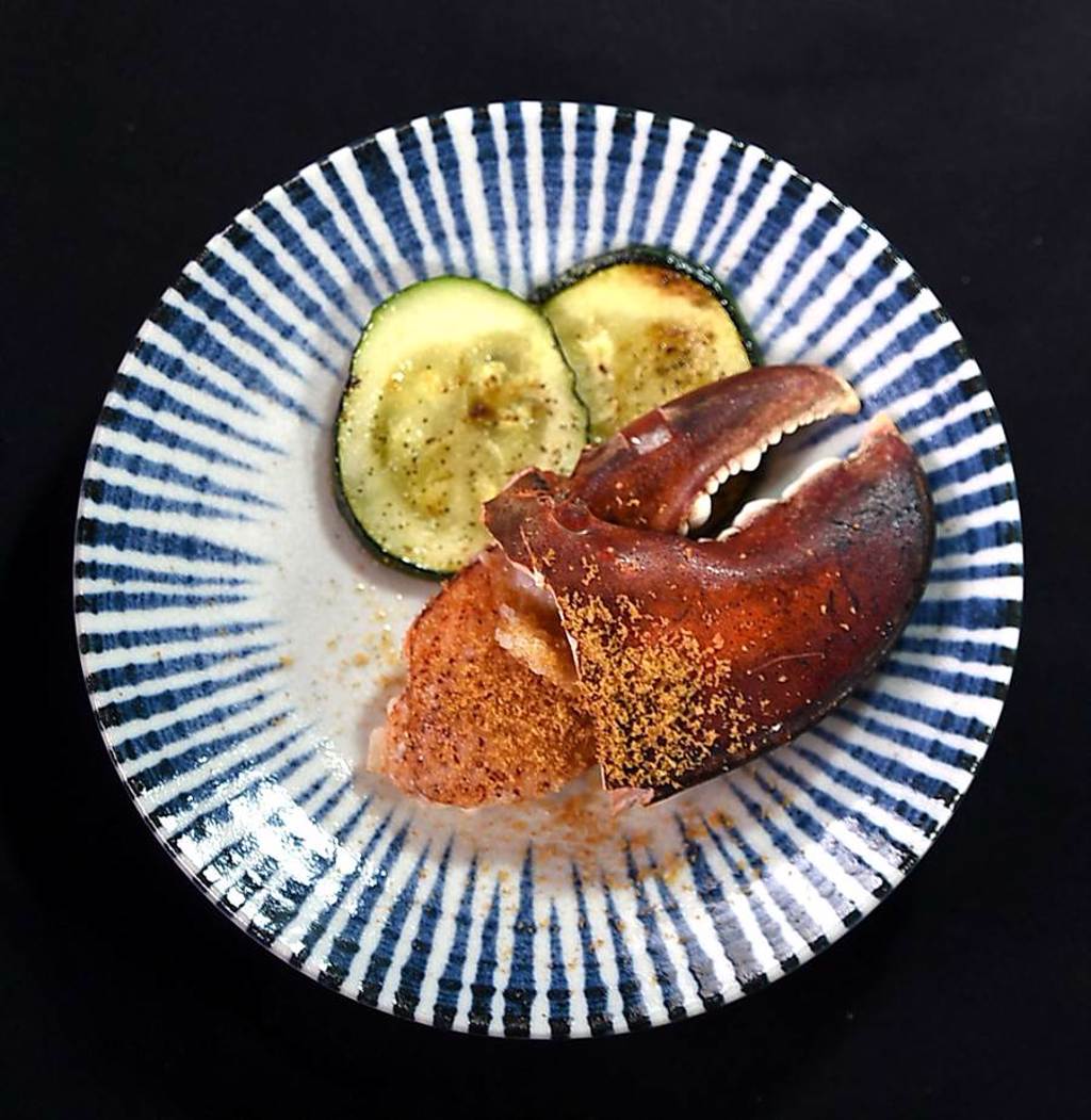 〈USHIMITSU犇和牛館〉的〈龍蝦螯佐烏魚子〉上桌時，會搭配鐵板香煎櫛瓜。（圖／姚舜）