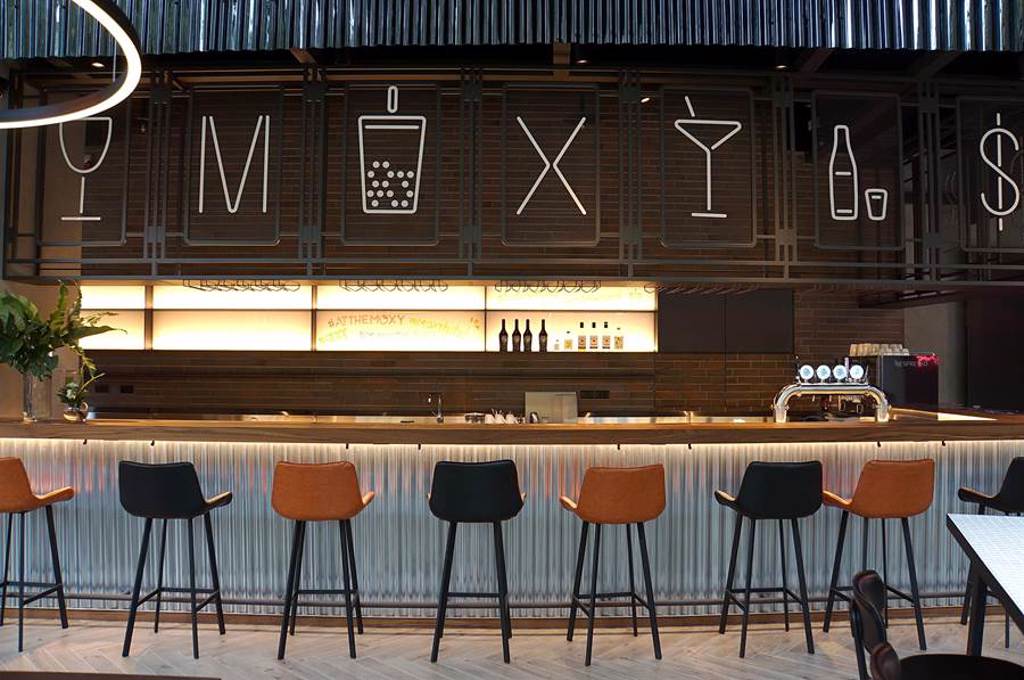 台中豐邑Moxy酒店樓大廳的「The Moxy Bar」延續輕工業風設計，與飯店前檯(The Now)一體成形。（圖／姚舜）