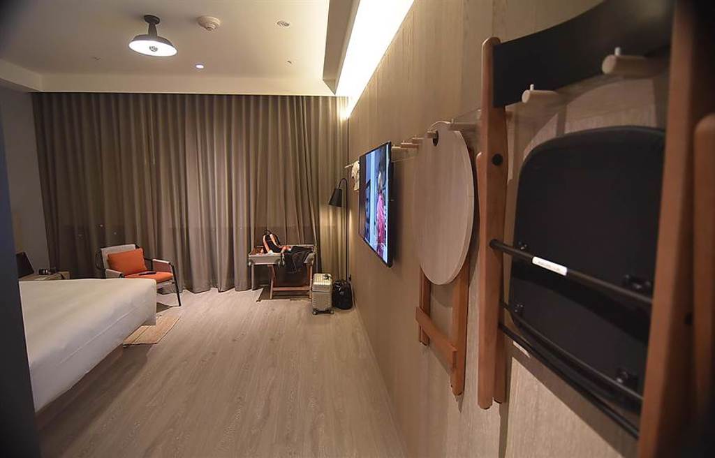 台中豐邑Moxy酒店客房內沒有用不到的奢華設備，折疊式傢俱收納掛在牆上。（圖／姚舜）