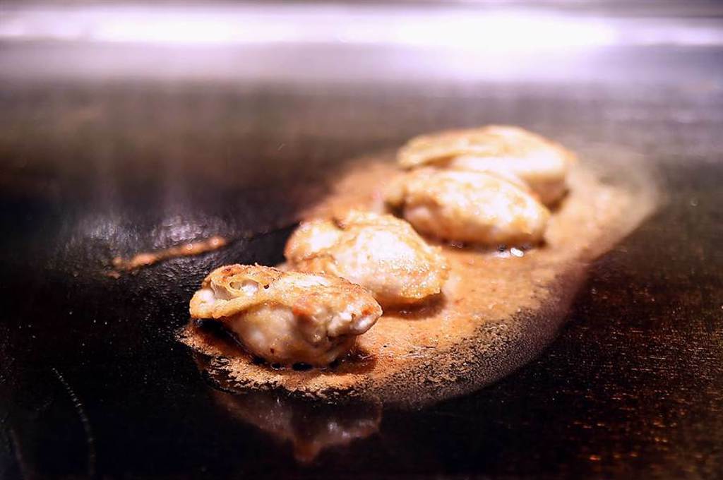 〈初魚 鐵板料亭〉敦北店烹製廣島牡蠣，是將口感富彈性並有濃厚海味的廣島生牡蠣，裹上日本細緻麵粉後香煎，再與其它食材搭配呈現。（圖／姚舜）