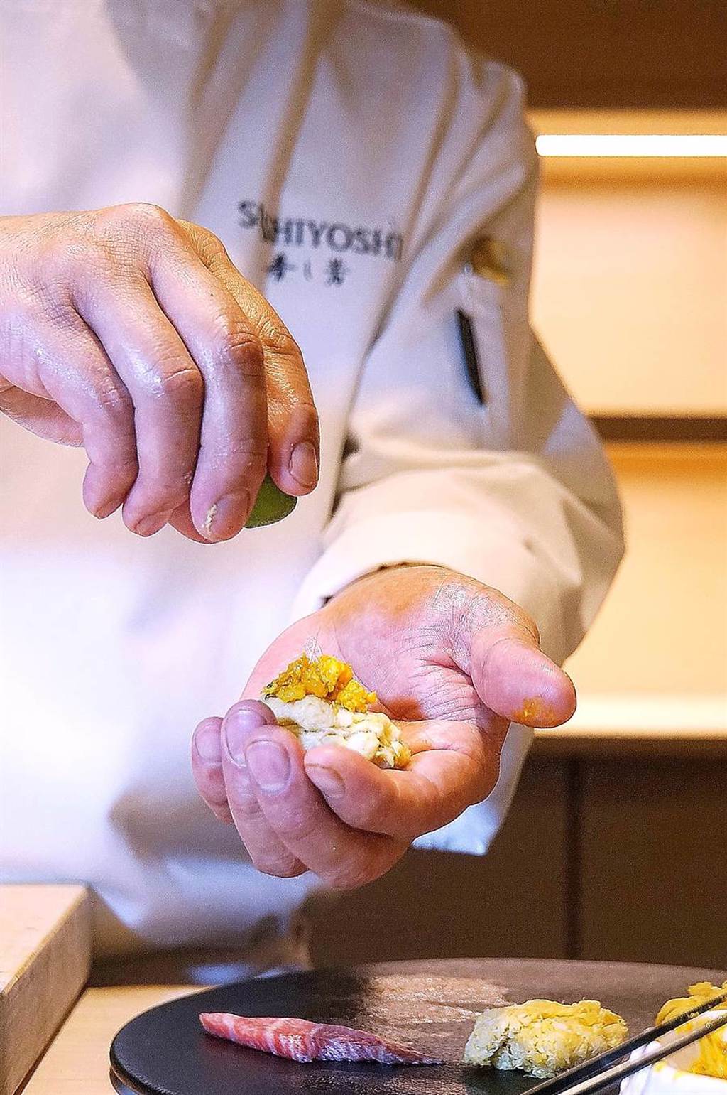 〈壽司芳〉推出季節限定大閘蟹套餐，廚師得先將大閘蟹蟹肉和蟹膏拆出備料，然後在板前做出各種美食供客人享用。（圖／姚舜）