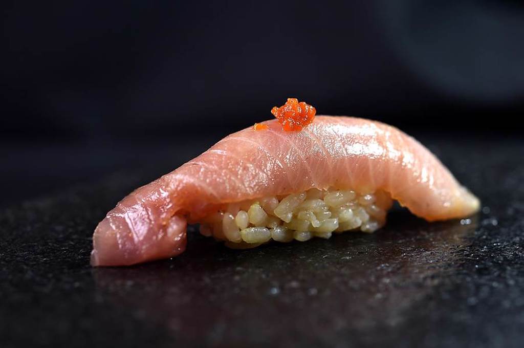 秋冬時節鰤魚愈見肥美，這貫〈鰤魚握壽司〉在上方點了一點熟成三年的寒作里辣椒醬提味。（圖／姚舜）
