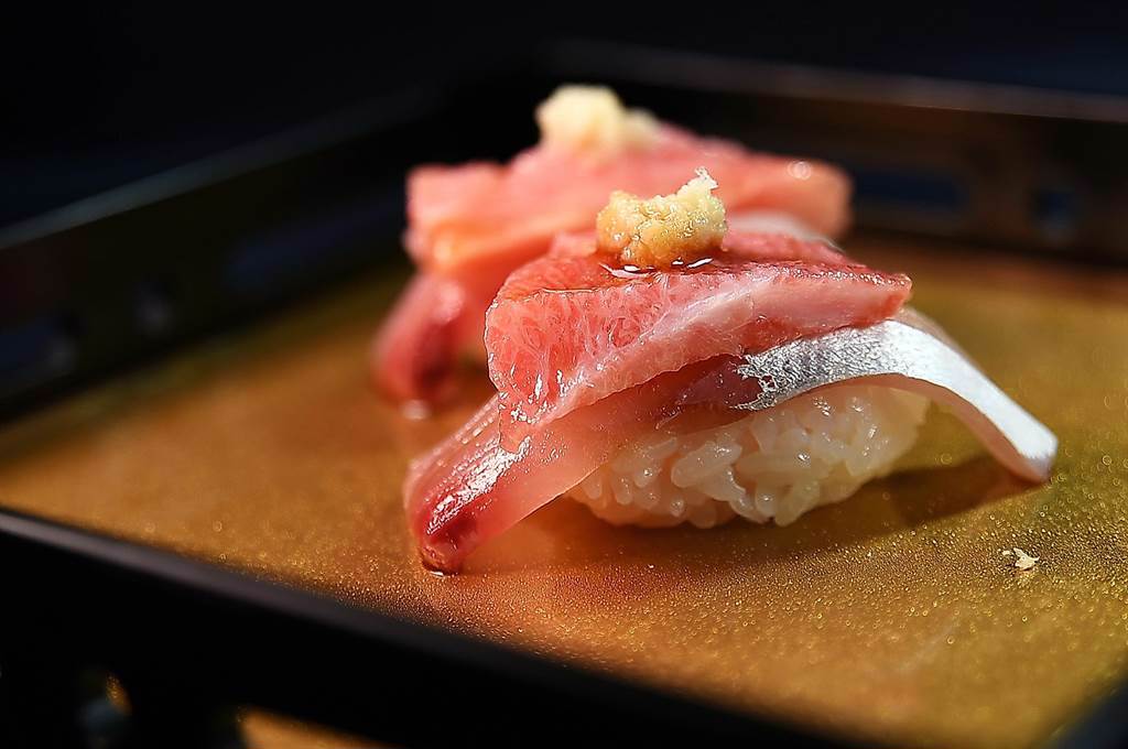 主打超值的〈米匠〉，九成以上的握壽司都是採2種以上複數食材捏製，且「保證一口吃不完」，圖為用俗稱「白魽」的牛港？和黑鮪魚一起組合的握壽司。（圖／姚舜）