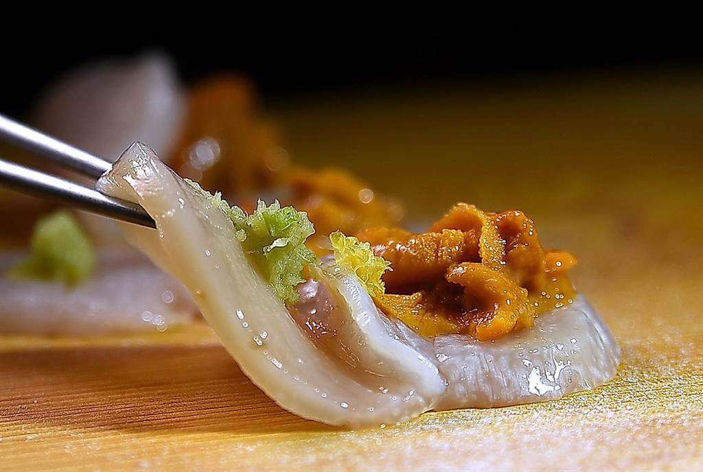〈干貝．海膽握壽司〉是將鮮甜的顆北海道大干貝，橫剖對切成兩片後包捲海膽、現刨檸檬絲、山葵泥和蘿蔔泥。（圖／姚舜)