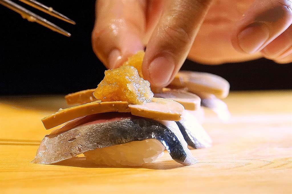 〈青花魚．安康魚肝握壽司〉也是以層疊的方式將兩種食材與醋飯組合呈現，最後並會以醋味蘿蔔泥和蝦荑蝦提味。(圖／姚舜）