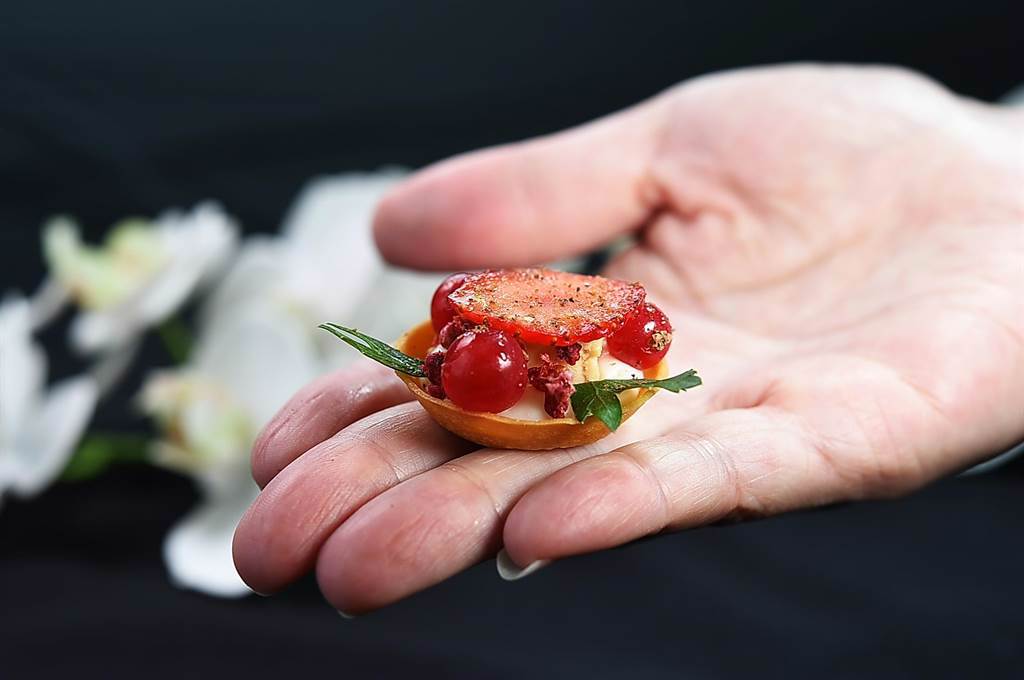 「六手聯烹驚炭宴」的Amuse Buche〈莓果鴨肝塔〉，是〈MIRAWAN〉主廚Josh鄭裕錞設計，法式塔皮中有西西里紅椒味的白醬和鴨肝，上層則有草莓和蔓越莓。（圖／姚舜）