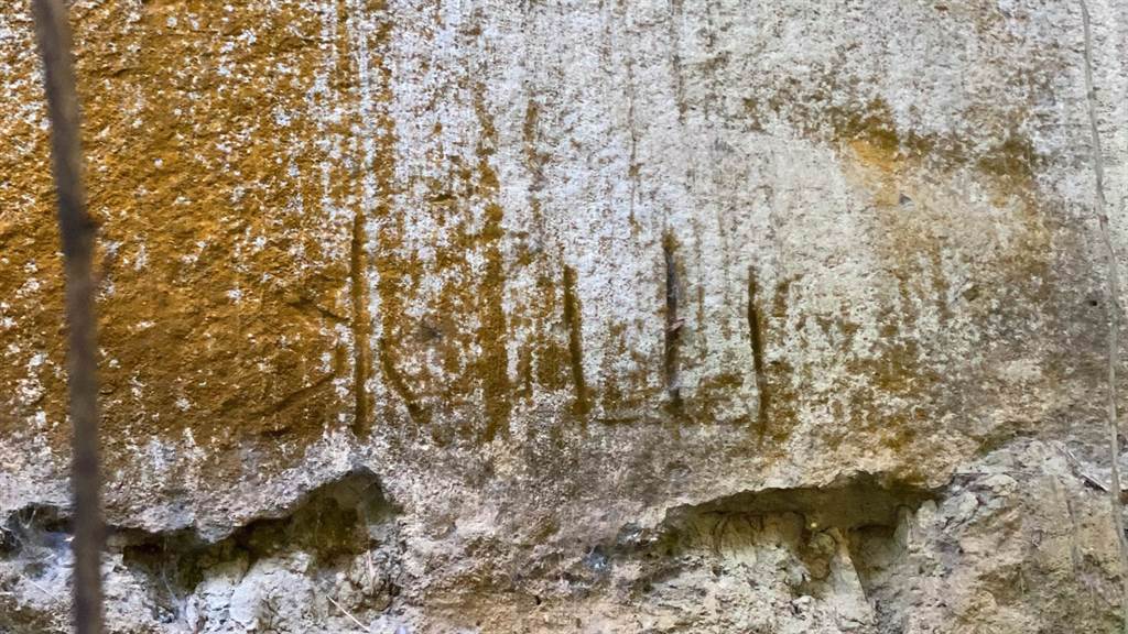 彰化市一線天祕境內山壁遭人刻字、塗鴉破壞，青苔上也出現一條條刮痕。（謝瓊雲攝）