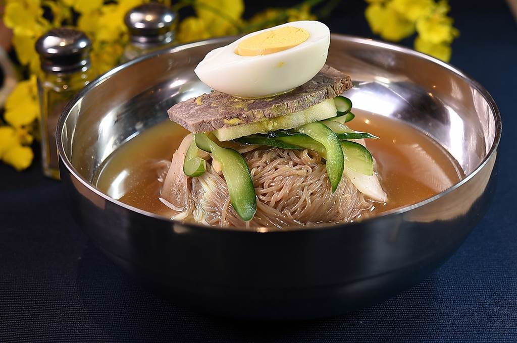〈SAIKABO〉的韓式〈水冷麵〉，湯頭是用水梨、白蘿蔔、薑、蒜熬製，口感彈Q的蕎麥麵並搭配了蘋果片、小黃瓜、牛腿肉， 以及半顆水煮蛋。（圖／姚舜）