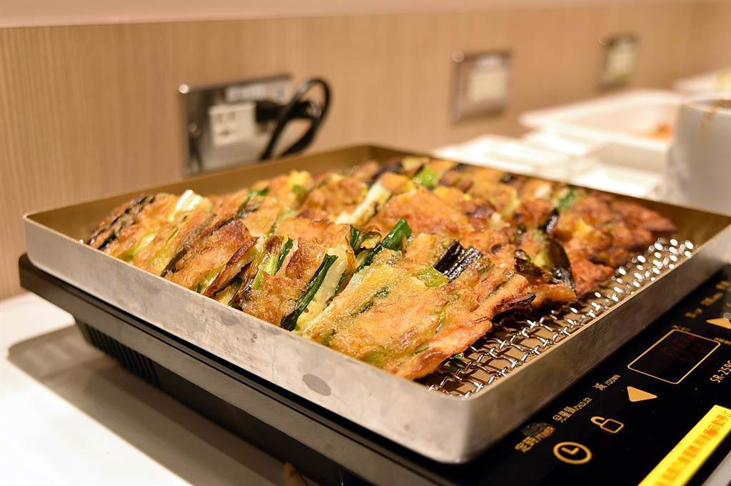 〈SAIKABO〉的自助餐檯上有〈香蔥煎餅〉與多種韓式泡菜，午餐時段單點菜品加99元就可無限取食吃到飽。（圖／姚舜）