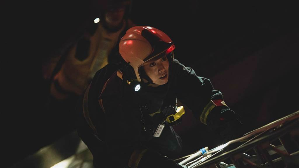 陳庭妮著消防衣驚險攀爬三層樓高的關東梯救援。（公視提供）