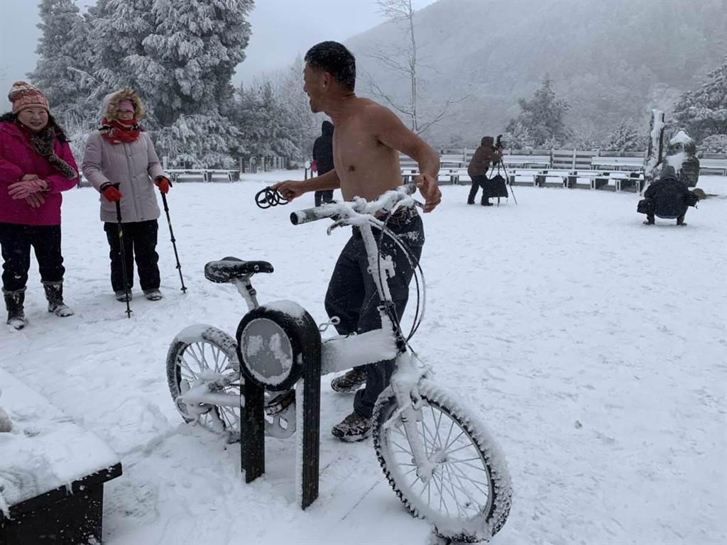 有遊客開心地在雪地中打赤膊騎自行車。（羅東林管處提供／胡健森宜蘭傳真）
