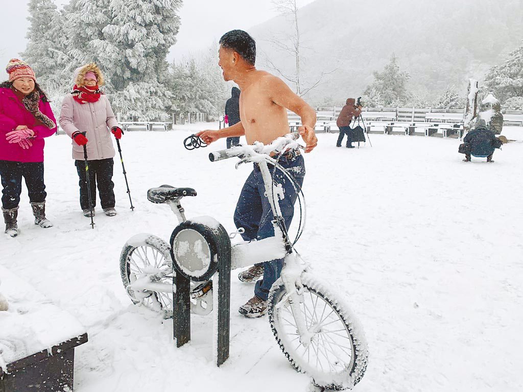 有遊客開心地在雪地中打赤膊騎自行車。（羅東林管處提供／胡健森宜蘭傳真）