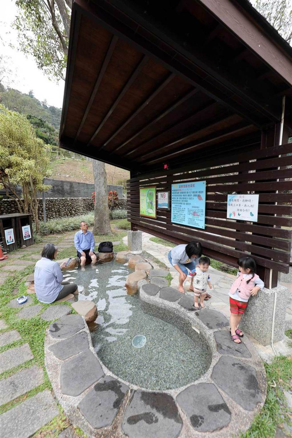 「谷關溫泉文化館」旁的公園區設有「溫泉魚去角質溫泉池」，不少人帶著一家大小來泡腳。（圖／于魯光攝）