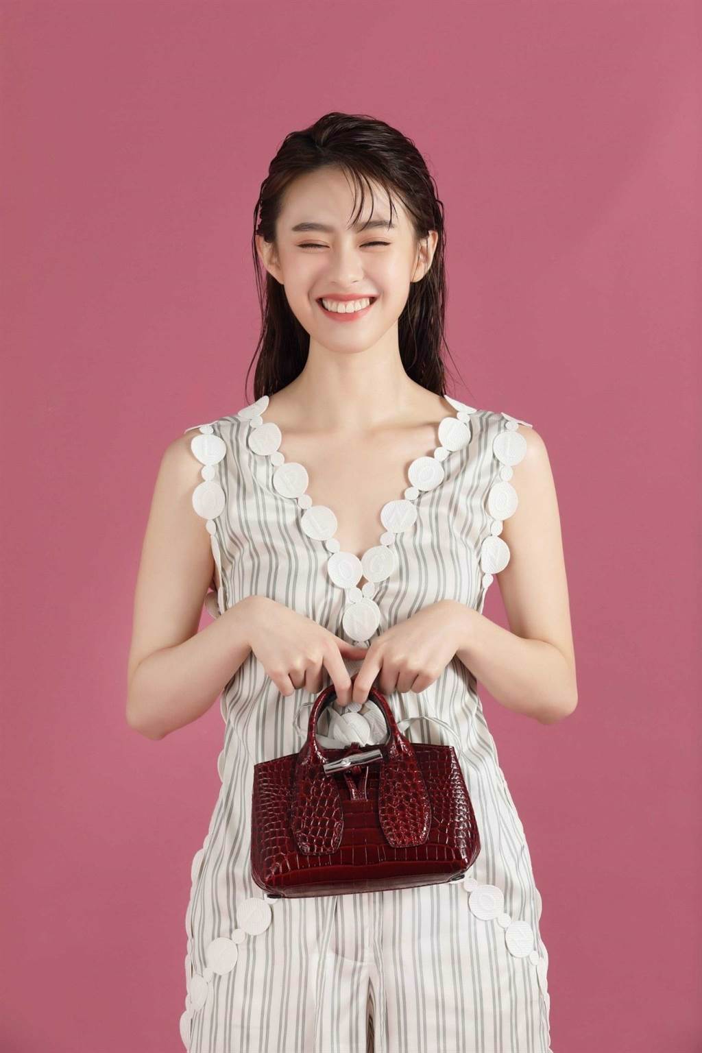 邱偲琹甜笑展現清新女孩風格，Longchamp 2021春夏服裝系列 LOGO絲綢連衣褲，2萬7100元，Roseau Croco 系列手提包 XS (酒紅色)，1萬7400元。（攝影 石智中）