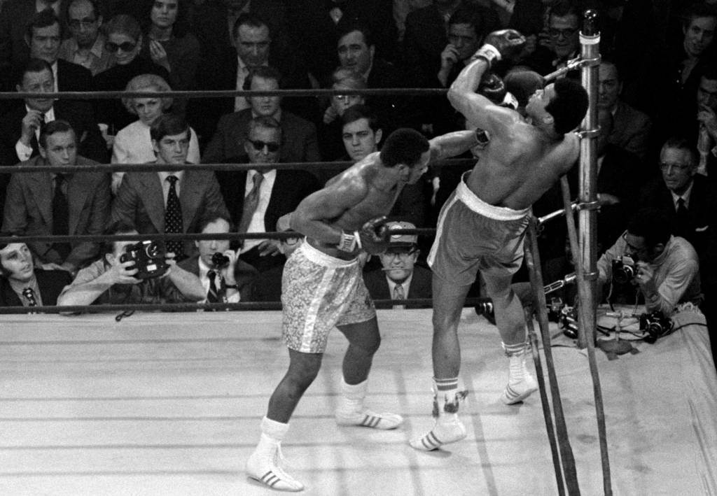 阿里(右)在1971年對戰弗雷瑟，被弗雷瑟的左拳逼得無路可逃，吞下職業生涯首敗。（美聯社資料照）