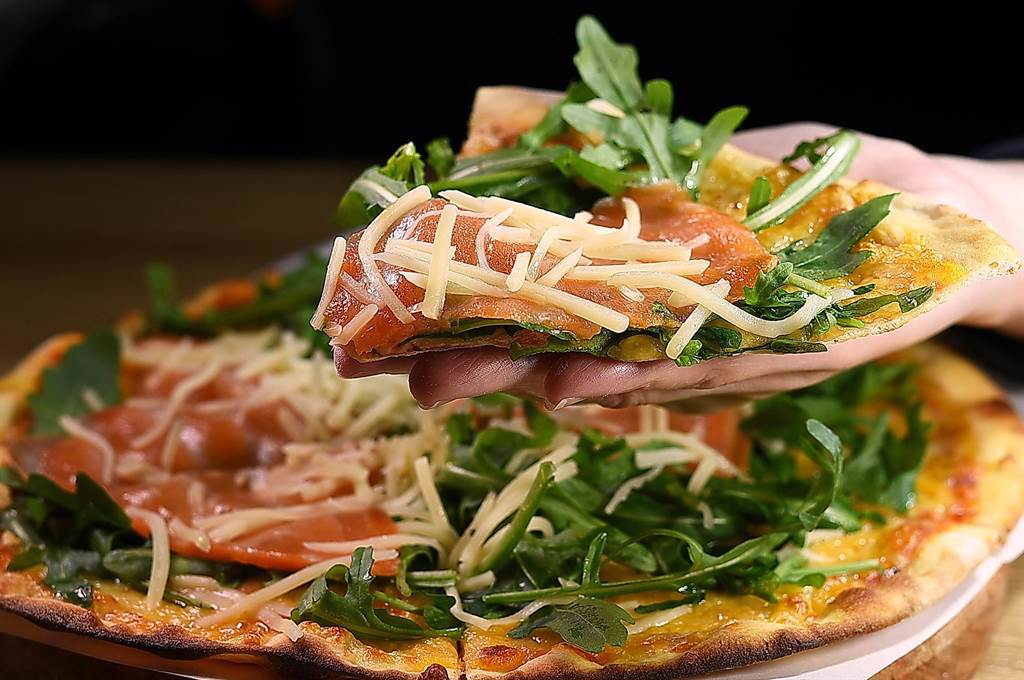〈Pino Pizzeria〉二店的〈煙燻芝麻葉Pizza〉，滿滿芝麻葉是主廚謝宜榮岳母在雲林種植的。（圖／姚舜）