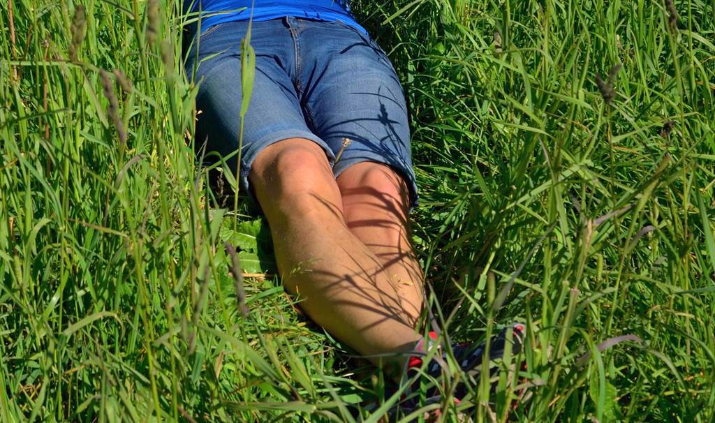 高雄一名女網友在路邊發現一名橫躺在草叢中的阿伯。(示意圖／達志影像)
