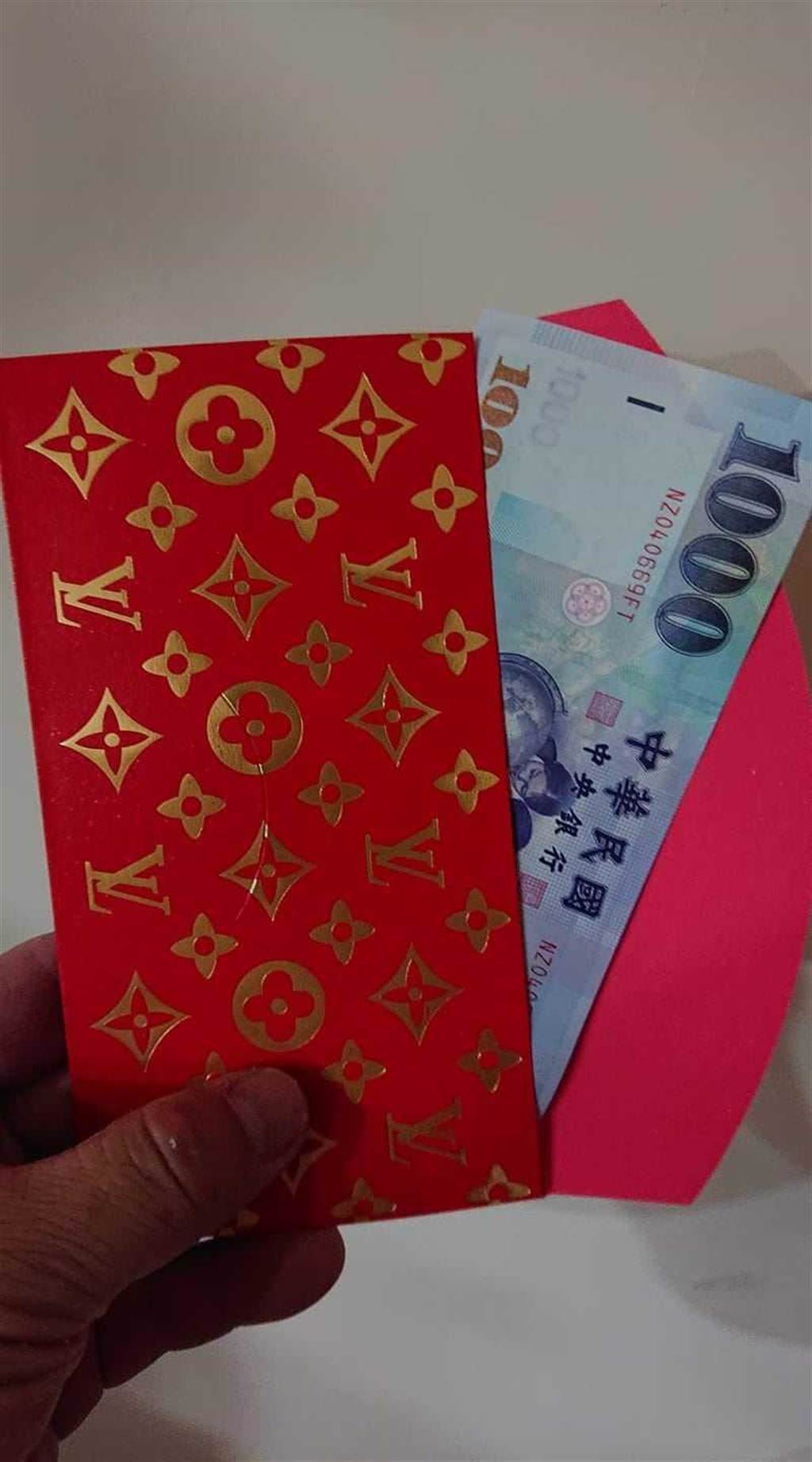 外送員開心收到裝有千元大鈔、印著「LV」LOGO的紅包。（圖／翻攝自臉書／UberEats全台討論區）
