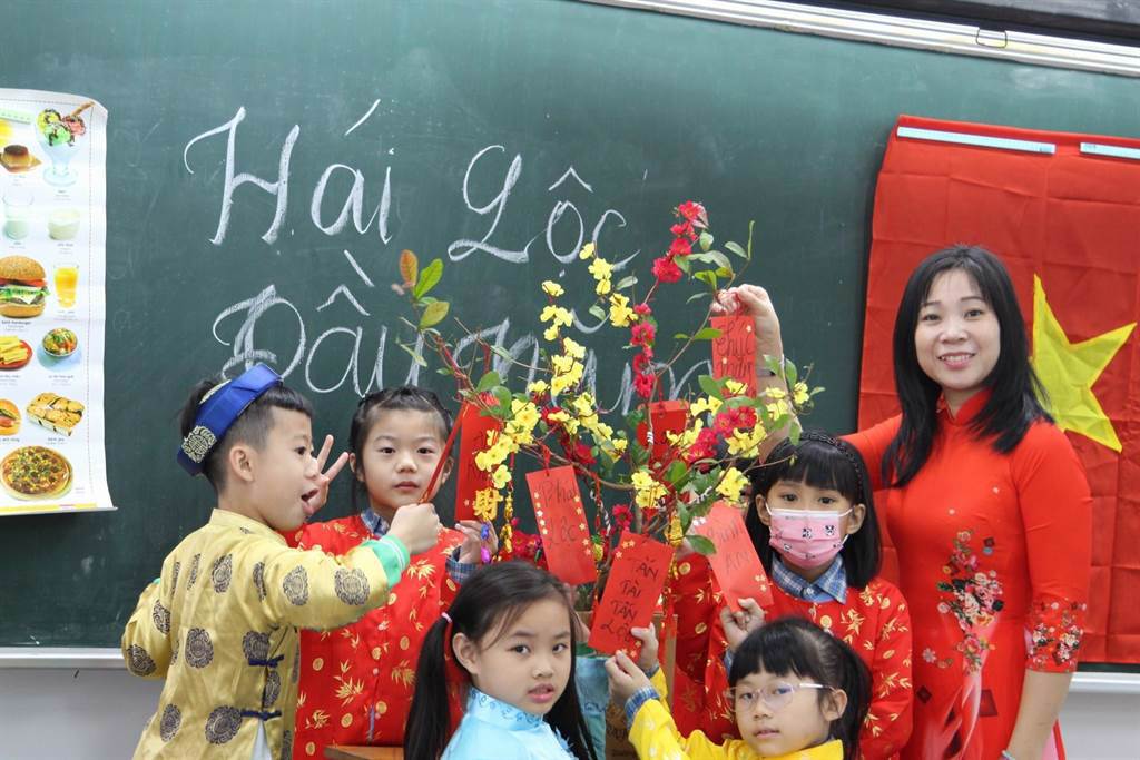 越南語老師阮紅女在教室內準備掛滿福袋的樹，讓學生摘下後帶回家，象徵著將今年的好運勢帶回家中。（教育局提供／李俊淇新北傳真）