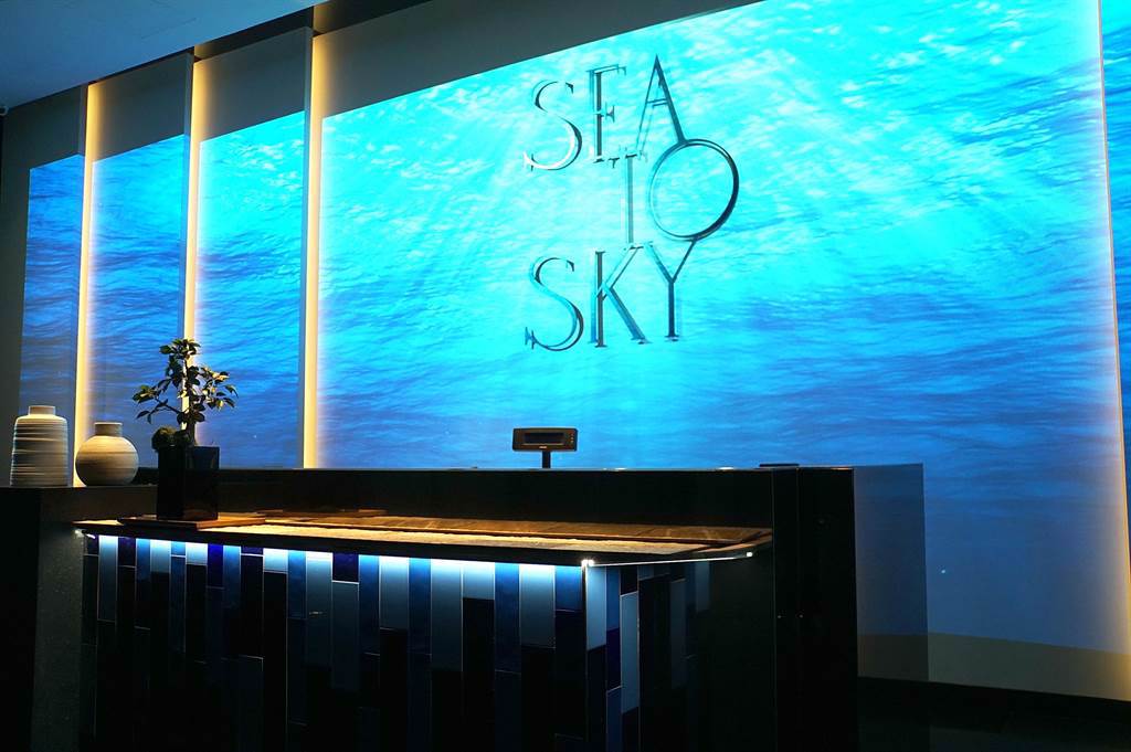 位在台北微風信義47樓的〈Sea To Sky〉，占地160坪，室內座位120席，戶外酒吧50席，共有4間包廂，餐廳以藍色為主調裝潢設計，營造出海天一線的舒適氛圍。（圖／姚舜）