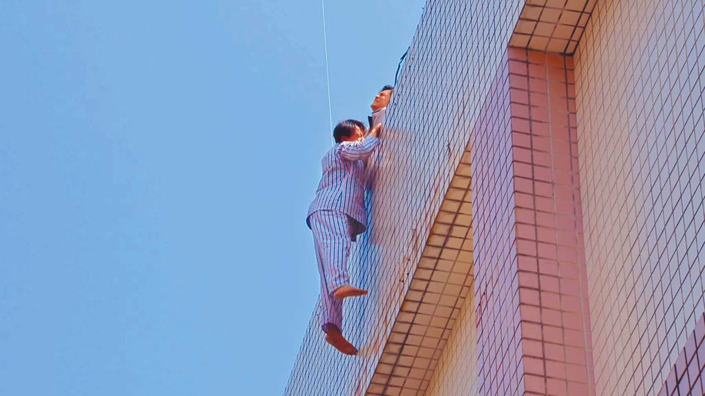 黃文星拍攝《多情城市》懸吊戲，高掛7樓牆外相當驚險。（民視提供）