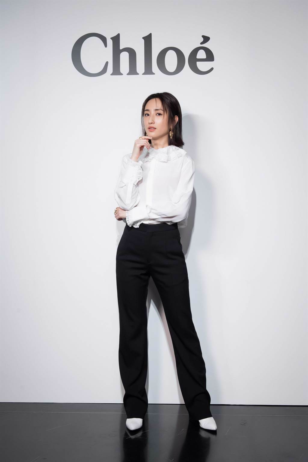圖一：柯佳嬿出席Chloe秋冬系列發表，與造型師討論以白色荷葉襯衫配黑褲，營造品牌清新感。（Chloe提供）