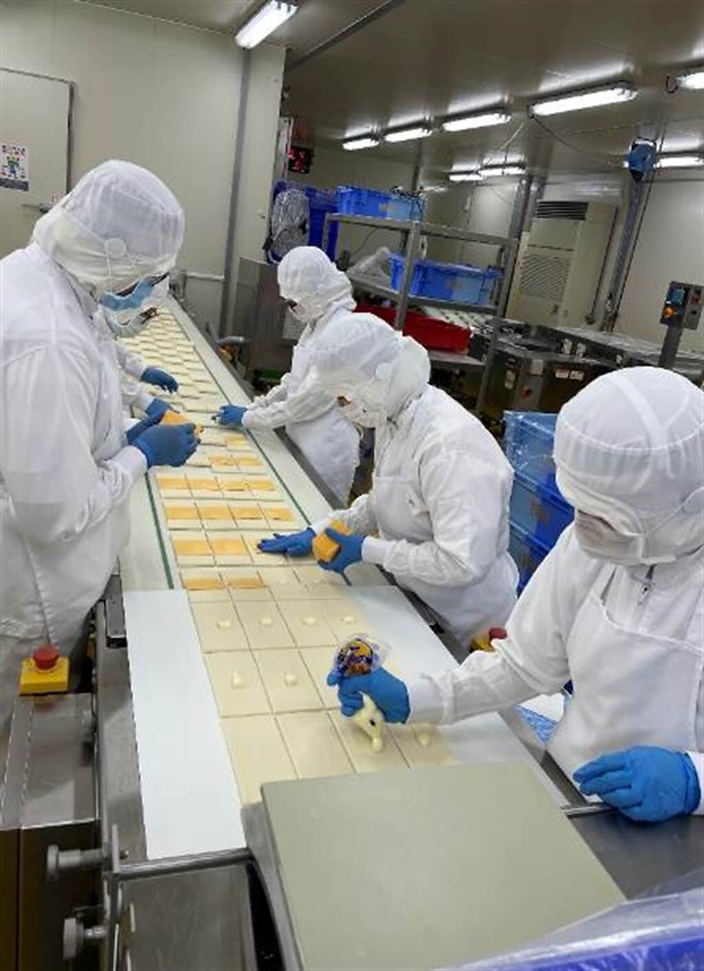 1個小時最高可生產9000個麵包的HM生產線，正在製作帕瑪森麵糰，麵皮層疊出口感，再手工加美奶滋+帕瑪森起司、整型。（郭家崴攝）