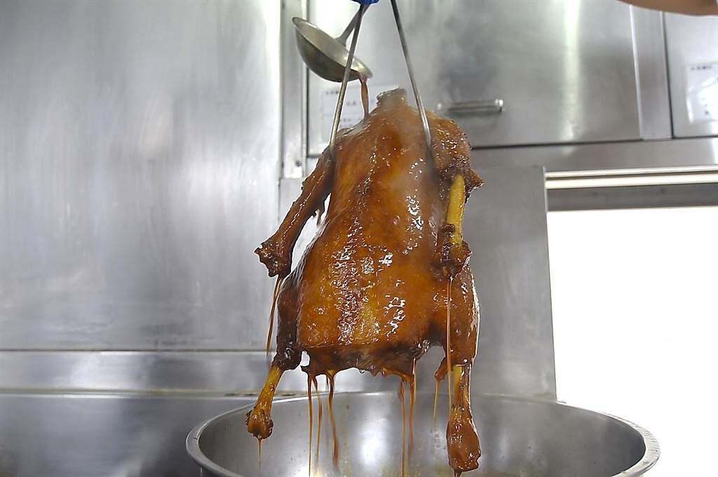 烹製〈碌鵝〉的最後一道工序是「掛汁」，將用水、陳皮、老薑、話梅和梅醬煮製的醬汁，反覆淋在鵝胚上使之上色並增益風味。(圖／姚舜)