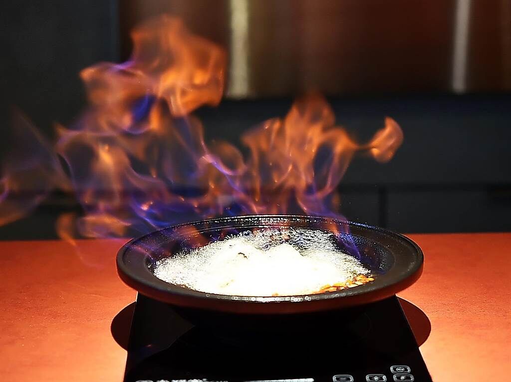 煮〈燒酒麻香鍋〉時點火讓酒精揮發過程，是〈萬客什鍋〉的賣點之一。（圖／姚舜）