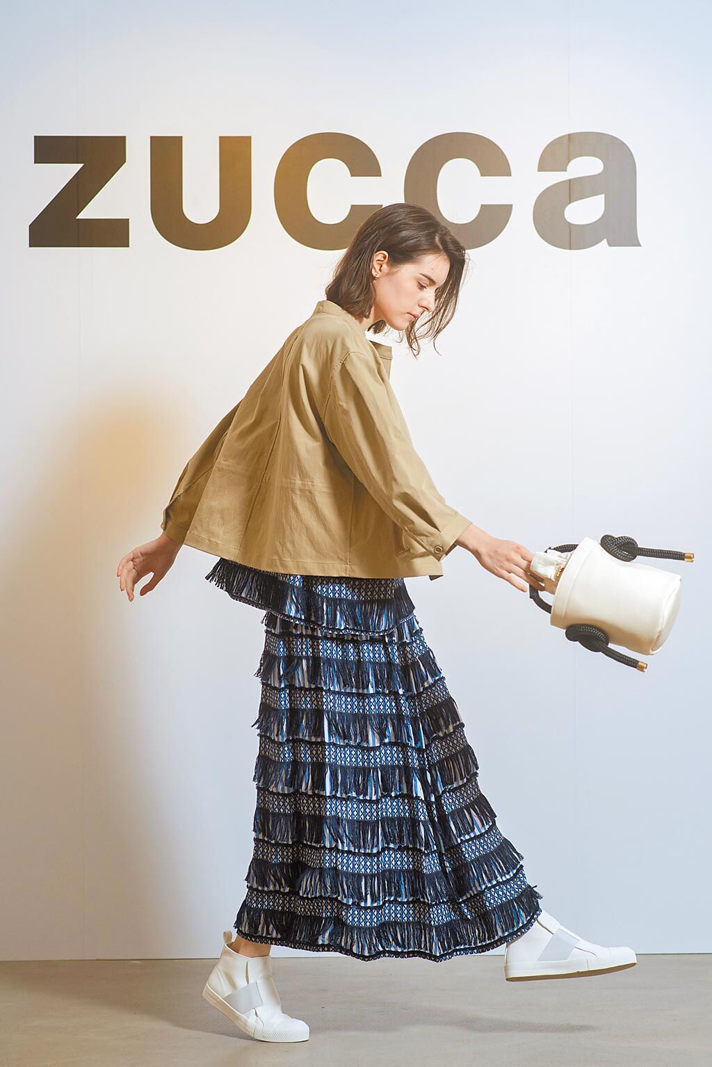 ZUCCa的最大賣點是異材質和手工設計。ZUCCa流蘇平織短袖上衣8600元、緞面流蘇長裙1萬7200元、輕盈卡其外套1萬6200元、繩結水桶手提包9200元。（君梵提供）