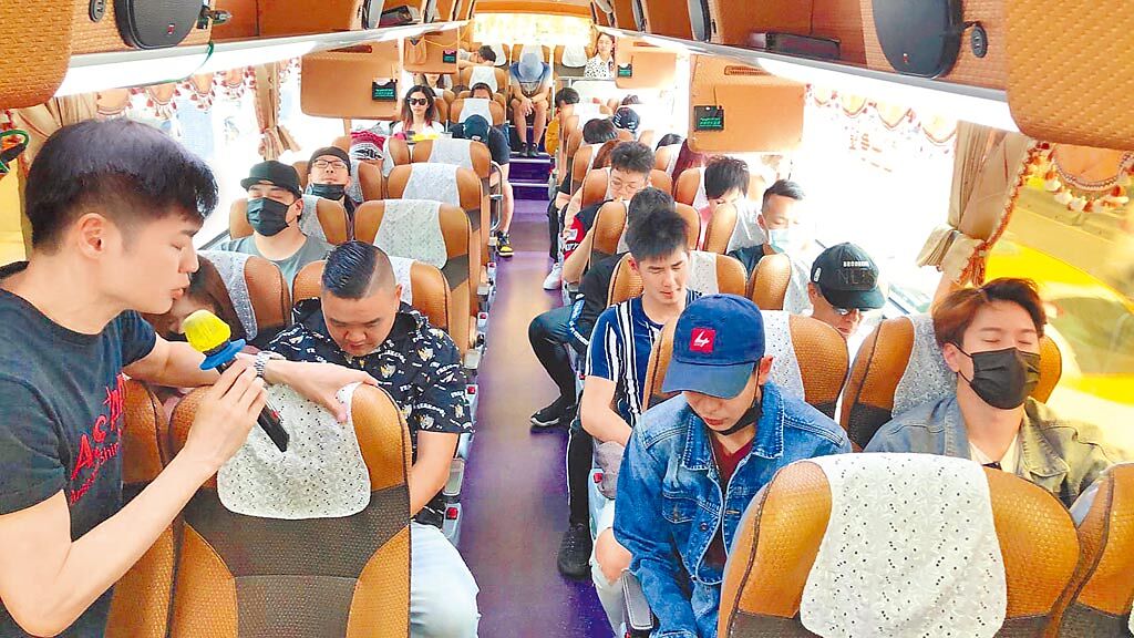 宋逸民（左）昨率藝起發光協會成員在遊覽車上為太魯閣號乘客祈禱。（摘自臉書）