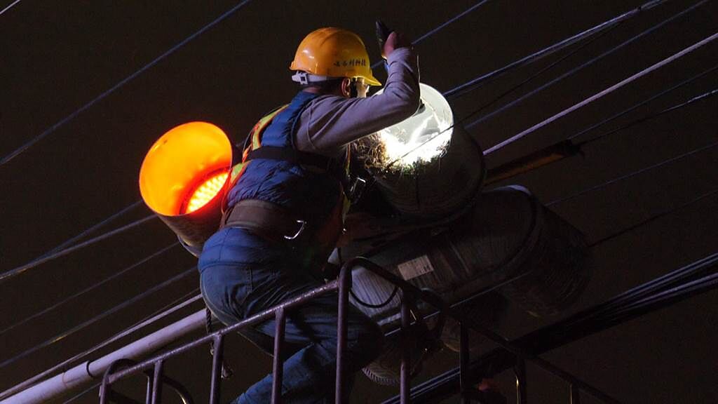 新北市交通局維修小組當天會同動保前往勘查，小心冀冀地連同鳥蛋移除鳥巢，讓綠燈「重回光明」。。（新北市交通局提供）