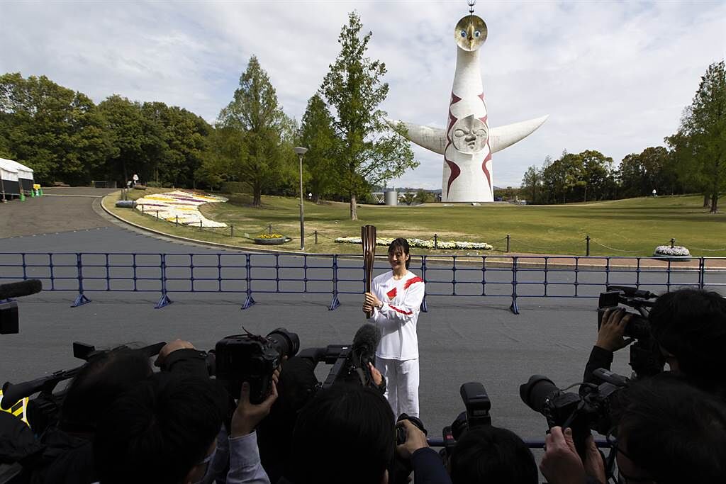 大阪府出生的前奧運游泳代表隊選手寺川綾，是傳遞東京奧運聖火的跑者之一，她在人煙稀少的大阪萬博紀念公園向媒體展示聖火火炬。（美聯社）