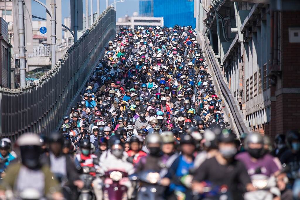 在上下班尖峰時間，台北橋形成的「機車瀑布」多次登上國際版面，甚至被日本綜藝節目評為台灣絕景。（圖／Shutterstock）