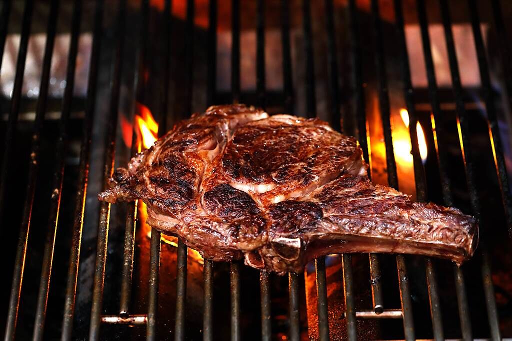 除了入口即化的日本和牛，更有以800至900度高溫炙烤的「澳洲 Blackmore 戰斧牛排」。（圖／品牌提供）