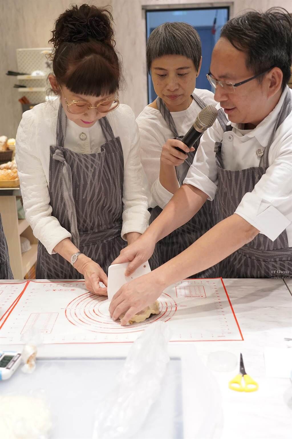遠百總經理徐雪芳（左）今出席遠百信義A13 全台首家「吳寶春自己做」全新概念體驗店，與吳寶春（右）一起做麵包。（遠百提供）