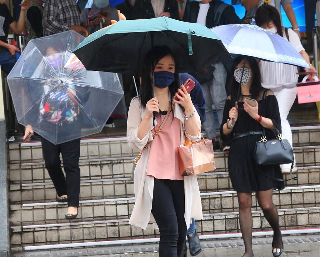 隨著鋒面接近，28日早上開始台北市就出現短暫陣雨，路上行人紛紛撐起傘來遮雨。（陳君瑋攝）