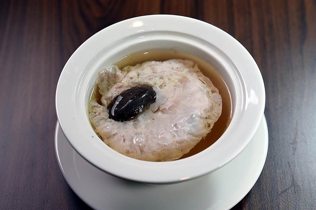 〈松露雲雞清湯〉是比照法式〈澄清湯〉（consomme)作法，用雞肉蓉將雞湯萃取過濾，雞蓉經高溫蒸燉後會產生「浮雲」效果在湯面飄浮。（圖／姚舜）