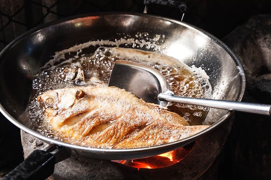 泰國網友在炸魚時，突然發現油鍋上的魚肉竟竄出成千上萬隻的白色幼蟲，讓她相當崩潰。（示意圖／達志影像）