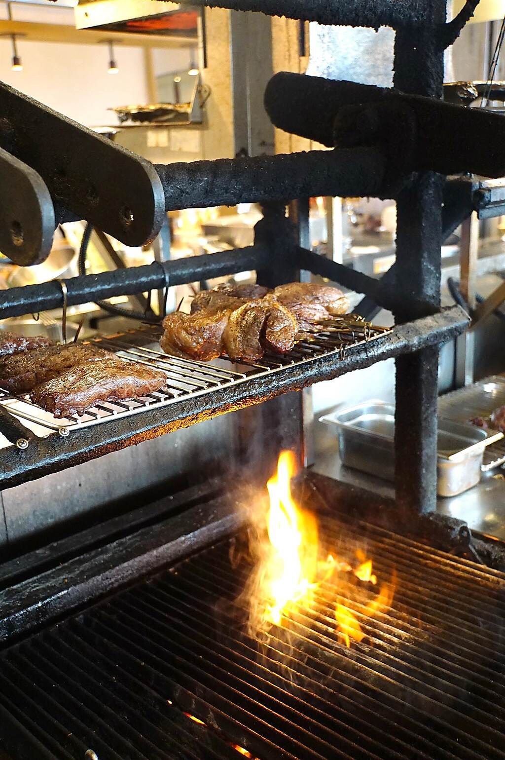 松山意舍〈Que〉餐廳的牛、豬、羊排，都是以原木直火燒烤，且客人看得到燒烤過程。（圖／姚舜）