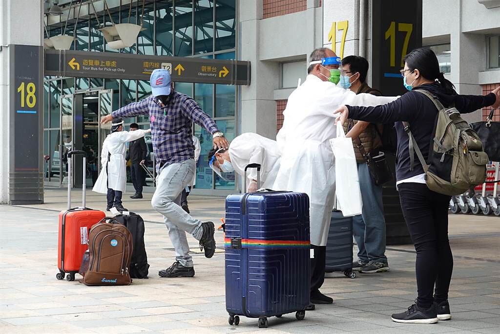 搭乘日航專機自印度返台的旅客，8日中午抵達台北松山機場，經防疫消毒後，乘坐遊覽車前往集中檢疫所。（姚志平攝）