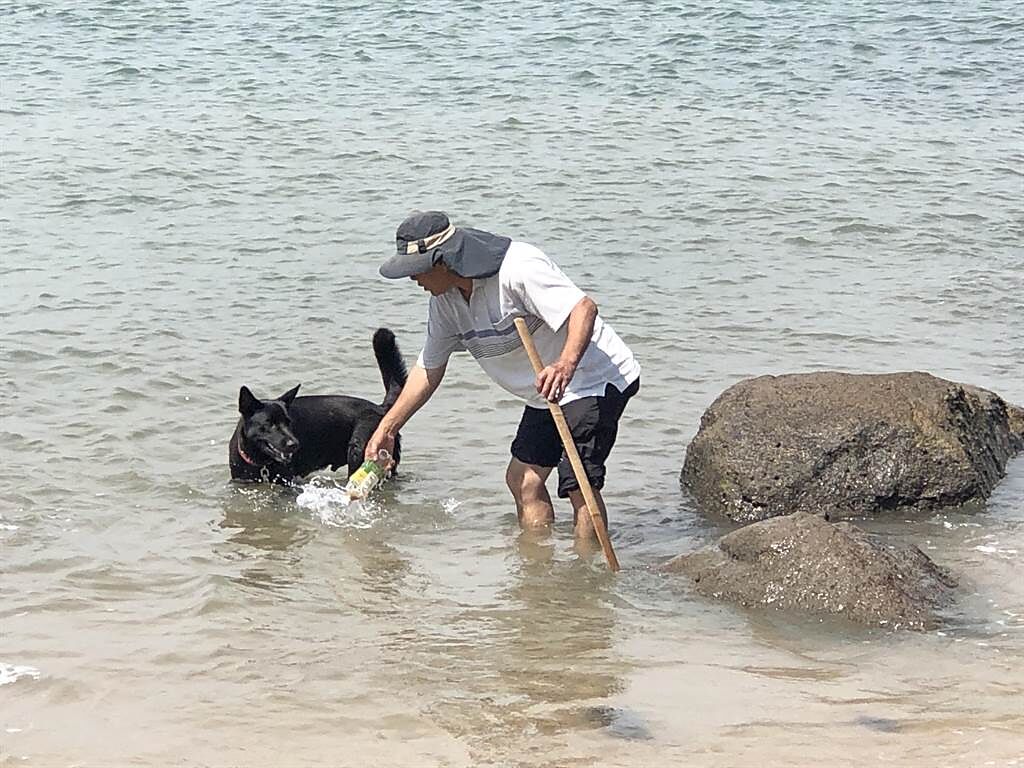 家住前水頭的金門酒廠老員工葉福和在今年2月4日，帶家中大黑狗「多多」到塔山電廠前方海灘玩，意外發現這顆奇怪的石頭。（李金生攝）