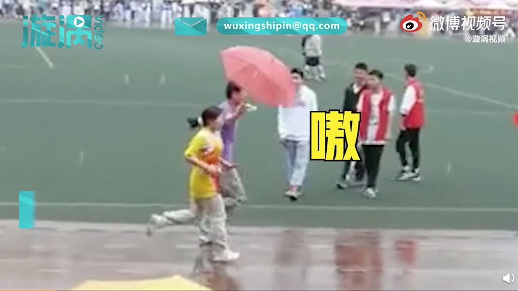 一名男同學看到女同學孤身一人在操場上淋雨，便趕緊為她撐傘跑完全程。（圖／微博＠漩涡视频 ）