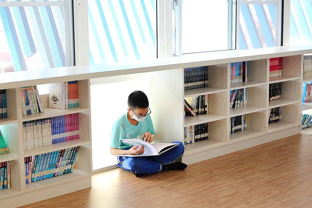 孩子們很喜歡在木板平台上看書，一個人窩在城垛書櫃的秘密基地，安靜地閱讀。（攝影/Carter）