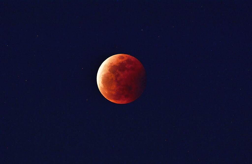 今天晚間7時許，血紅的月亮掛在台東的東方低空。（莊哲權攝）