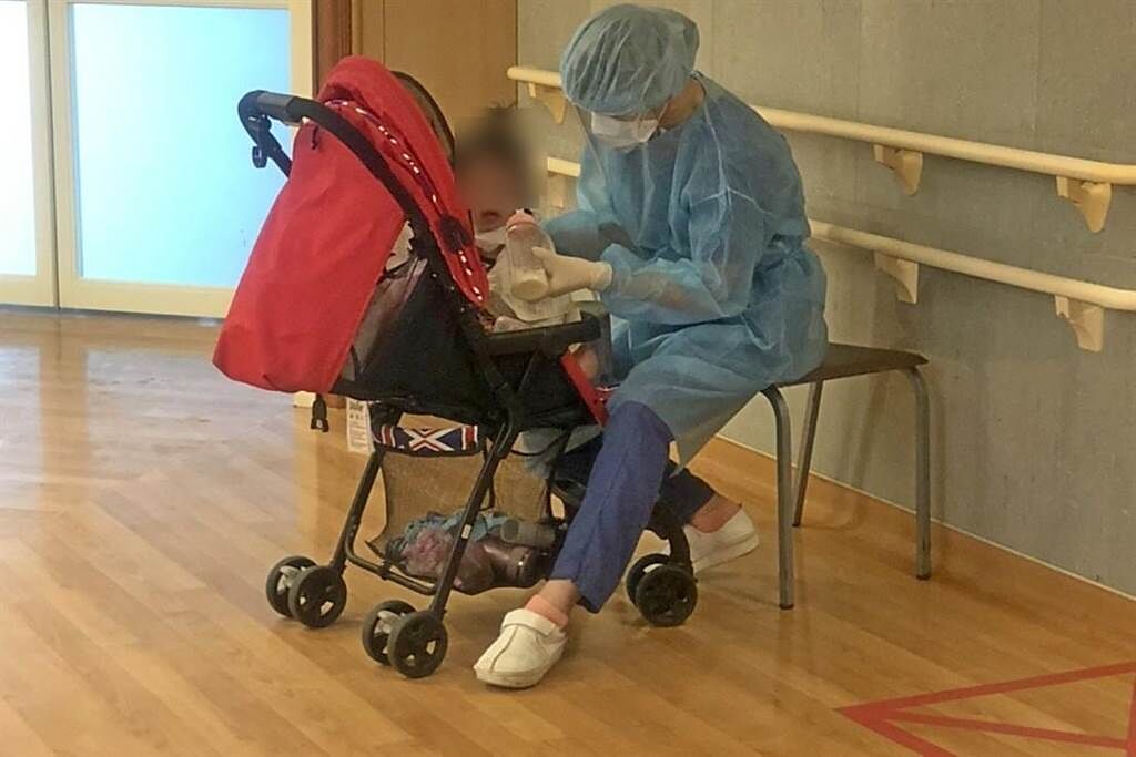 護理師在護理站當起保母、餵女嬰喝牛奶，一旁護理師拍下照片。（台北慈濟醫院提供）