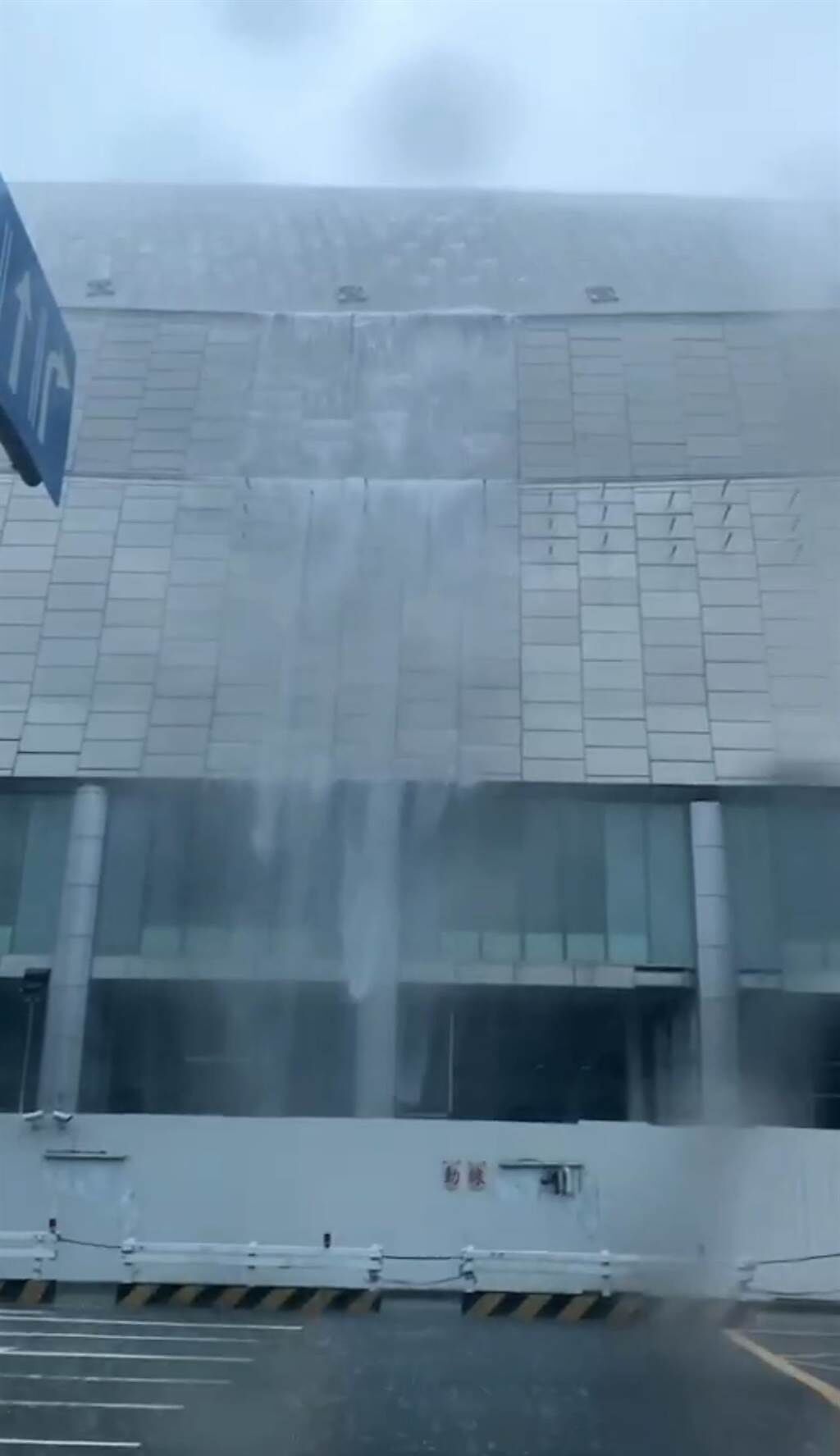 中央氣象局發布豪大雨特報，有民眾直擊拍下大巨蛋從「蛋頂」沖下的瀑布影片，疑惑直呼「排水系統呢？」。（民眾提供／張穎齊台北傳真）