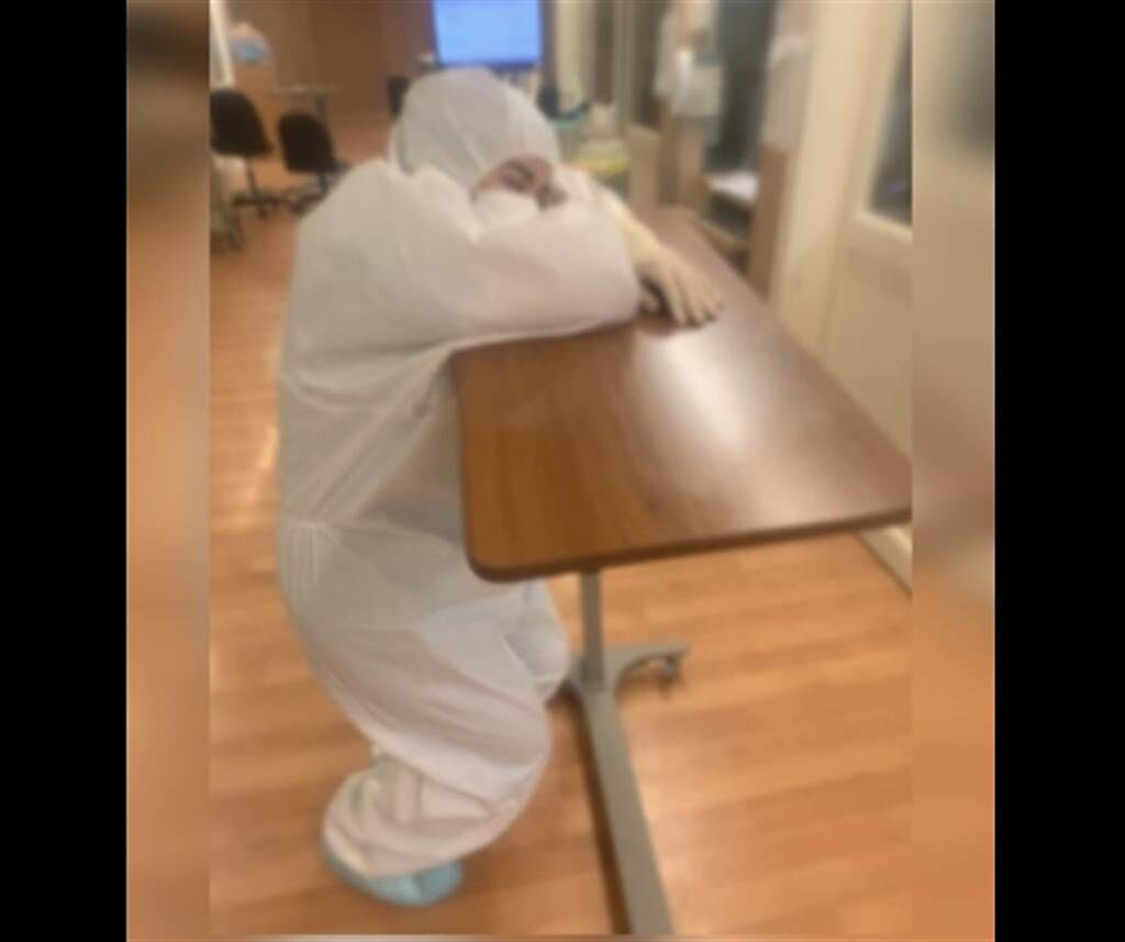 從照片中可見，醫護人員穿著防護衣靠在桌上的模樣，令眾人不捨。(圖截自臉書/林婷一下吧 icu護理師)