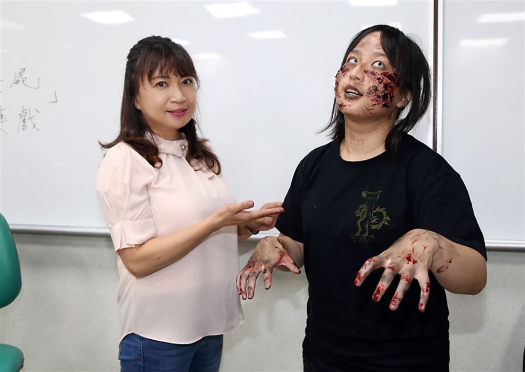 廖美慧與她一手打造的喪屍模特兒合影。（圖/世新大學提供）